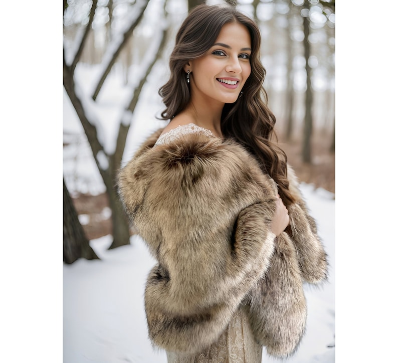 May include: A brown faux fur shawl with a long, flowing design. The shawl is worn by a person with long, dark hair and is standing in a snowy forest setting.