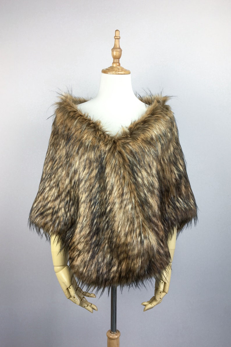 May include: A brown faux fur shawl with a V-neckline. The shawl is displayed on a wooden mannequin.