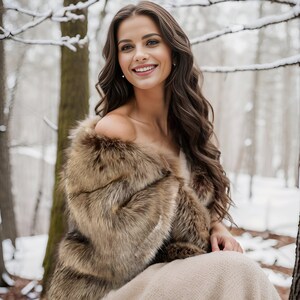 May include: A woman wearing a brown faux fur shawl over a beige dress, sitting in a snowy forest. She is smiling and looking at the camera.