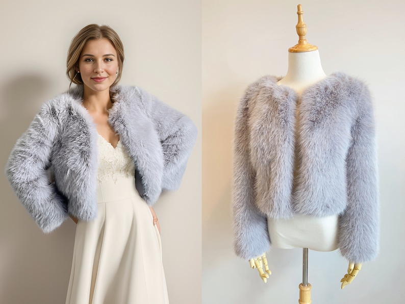 May include: A light gray faux fur shrug with a cropped length. The shrug is open in the front and has long sleeves.