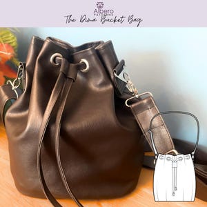 Pode incluir: Uma bolsa preta com fecho de cordão e ilhós de metal prateado. A bolsa tem uma alça de ombro e uma alça menor. O texto "Albero Patterns" e "The Dima Bucket Bag" está na parte superior da imagem.