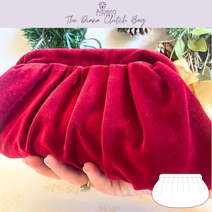 Puede incluir: Un bolso de mano de terciopelo rojo con un diseño fruncido. El bolso se sostiene en una mano y tiene el texto "The Diana Clutch Bag" en la parte superior. Un dibujo del bolso está en la esquina inferior derecha.