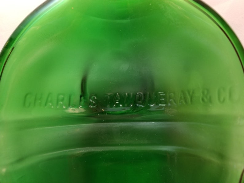 May include: A green glass bottle with the text "CHARLES TANQUERAY & CO" embossed on the bottom.
