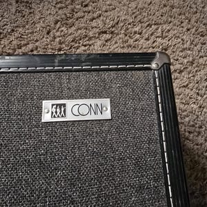 May include: Black fabric case with a silver metal plate that reads "CONN" and a small image of marching band members.