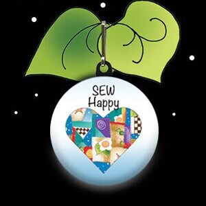 May include: A blue and white zipper pull charm with a heart-shaped patchwork design and the text "SEW Happy".