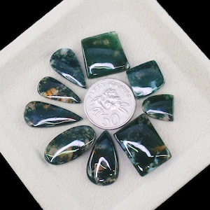 May include: A set of three ceramic mugs with a speckled, matte finish. Each mug features a different color: light blue, cream, and gray. The mugs have a simple, modern design with a rounded shape and a handle.