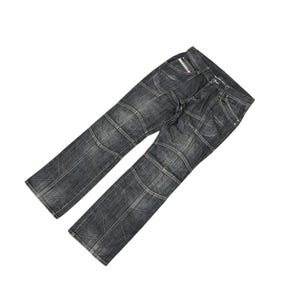 May include: Dark gray denim jeans with a patchwork design. The jeans have a straight leg cut and feature visible stitching details. The jeans are angled against a white background.