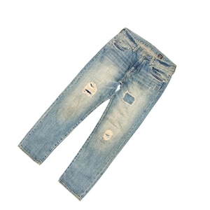 May include: Light blue denim jeans with distressed details, including ripped sections on the knees. The jeans have a classic five-pocket design and a faded wash for a worn look. The jeans are laid flat against a white background.