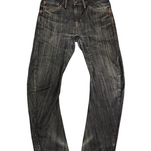 Op de afbeelding: Donkerblauwe denim jeans met een vervaagde, versleten uitstraling. De jeans hebben een klassiek vijf-zakken ontwerp, een knoop- en ritssluiting en oranje stikseldetails. De tailleband heeft een patroonvoering.