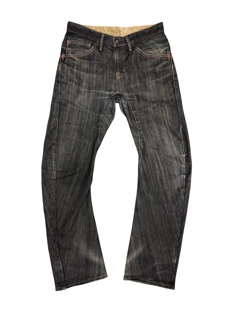 Op de afbeelding: Donkerblauwe denim jeans met een vervaagde, versleten uitstraling. De jeans hebben een klassiek vijf-zakken ontwerp, een knoop- en ritssluiting en oranje stikseldetails. De tailleband heeft een patroonvoering.