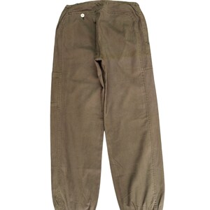 May include: A pair of brown cargo pants with a button on the back. The pants have a drawstring at the bottom of the legs.