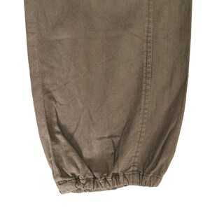 May include: Close-up of the bottom of a pair of brown pants with a drawstring.