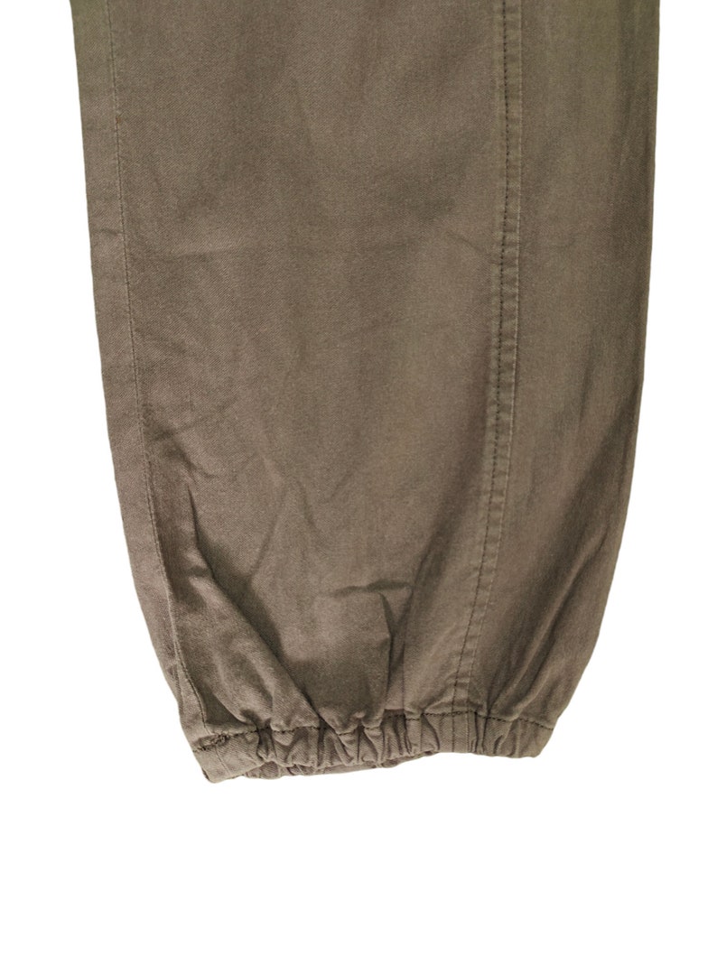 May include: Close-up of the bottom of a pair of brown pants with a drawstring.