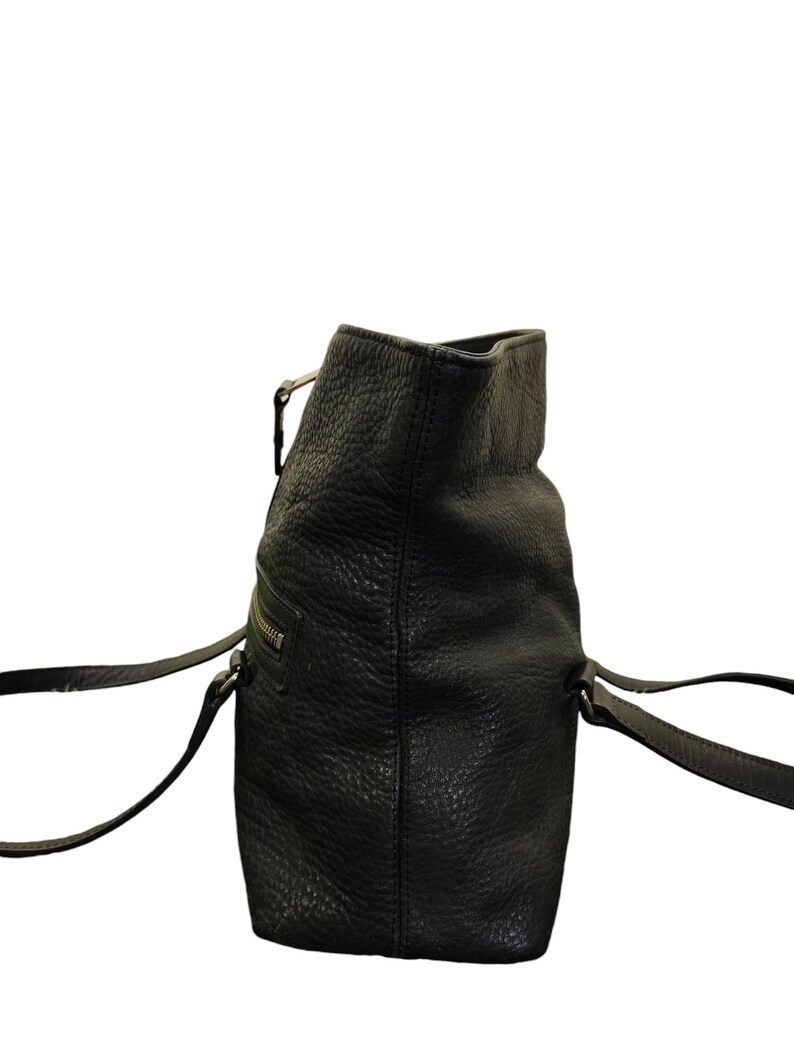 May include: A black leather tote bag with two top handles and a zip closure.