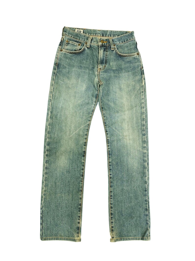 May include: Light blue denim jeans with a classic five-pocket design. The jeans have a faded wash and a straight leg cut. The image shows the jeans laid flat against a white background, showcasing the details of the stitching and the overall style.