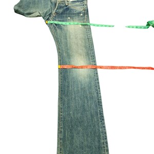 Puede incluir: Vaqueros de mezclilla azul claro con un lavado descolorido. Los vaqueros est&aacute;n colocados planos con cintas m&eacute;tricas en la cintura, el muslo y el dobladillo. Los vaqueros tienen bragueta con botones y dise&ntilde;o cl&aacute;sico de cinco bolsillos. Medidas en cm.