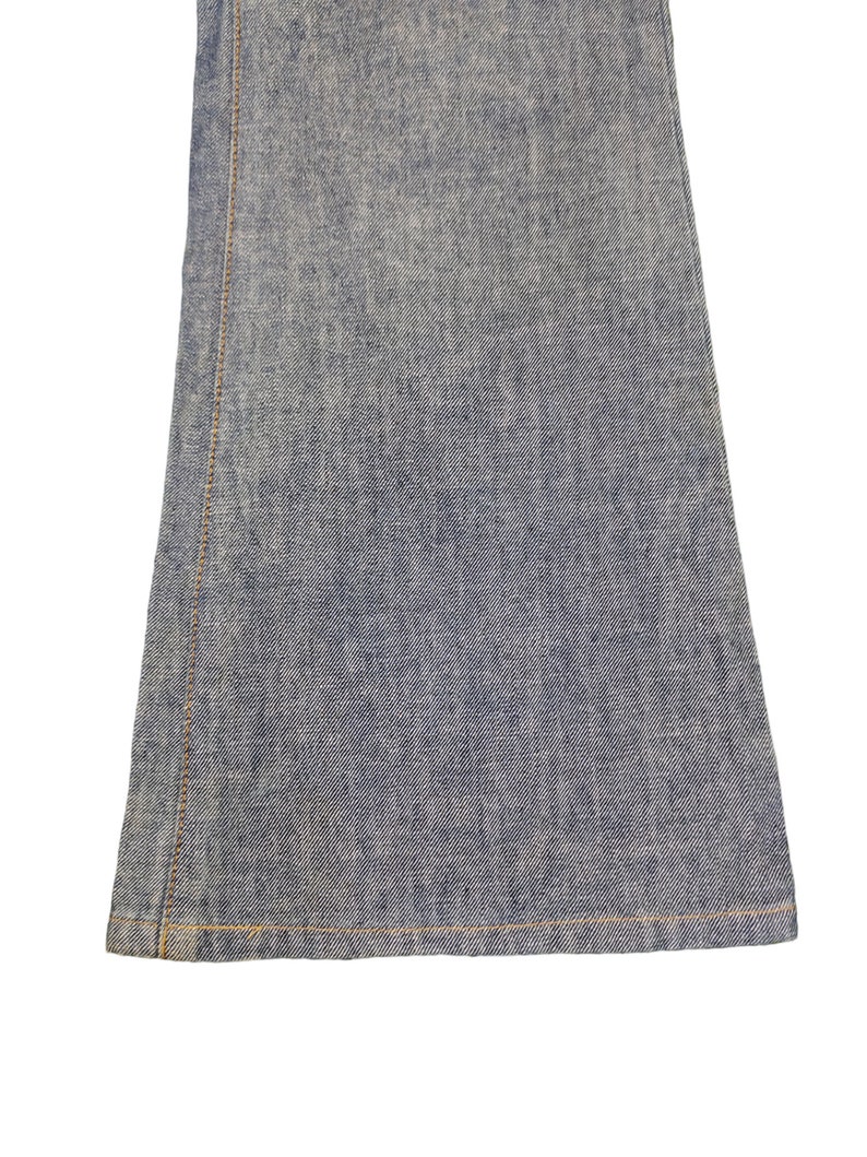 May include: Close-up of the bottom hem of a pair of blue denim jeans. The jeans have a straight leg and a raw hem.