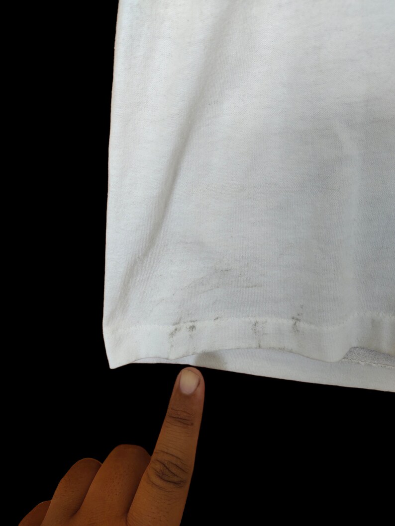 May include: White t-shirt with a slight discolouration on the bottom hem.