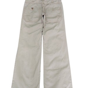 Puede incluir: Un pantal&oacute;n de pierna ancha de color beige claro con dos bolsillos grandes en la parte posterior.