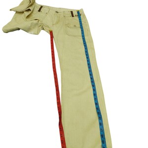 Puede incluir: Vaqueros de mezclilla amarillo claro con costuras y detalles marrones. Los vaqueros tienen un dise&ntilde;o cl&aacute;sico de cinco bolsillos y una pernera recta. La longitud total es de aproximadamente 107 cm.