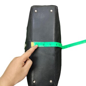 May include: Black leather handbag with silver hardware and a measuring tape showing the bag is 10 cm wide.