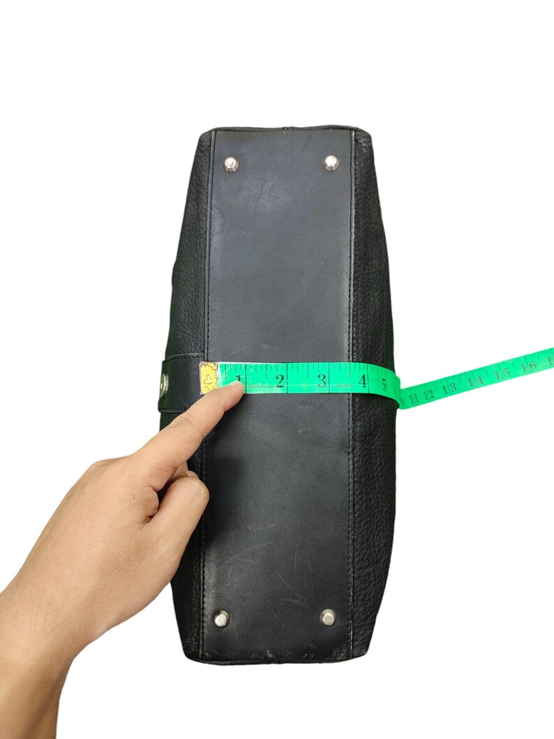 May include: Black leather handbag with silver hardware and a measuring tape showing the bag is 10 cm wide.