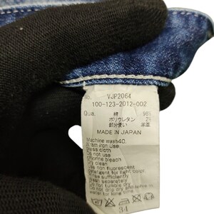 May include: Close-up of a denim garment tag with the text "VJP2064" and care instructions. The tag indicates the garment is made in Japan and includes washing and ironing guidelines. The size is indicated as 34.