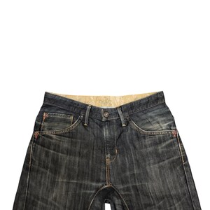 Op de afbeelding: Donkerblauwe denim jeans met een knoopsluiting en een klassiek vijf-zakken ontwerp. De jeans heeft oranje stiksels en rode accenten op de zakken. De jeans heeft een middelhoge taille en een rechte pijp.