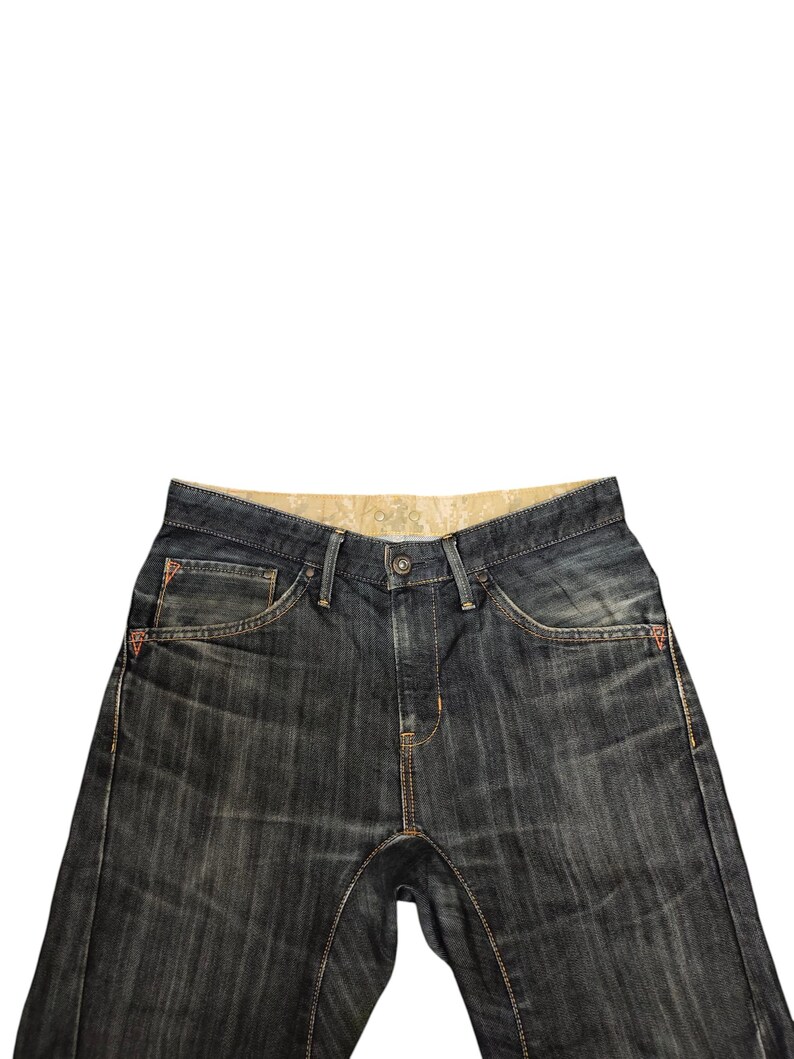 Op de afbeelding: Donkerblauwe denim jeans met een knoopsluiting en een klassiek vijf-zakken ontwerp. De jeans heeft oranje stiksels en rode accenten op de zakken. De jeans heeft een middelhoge taille en een rechte pijp.