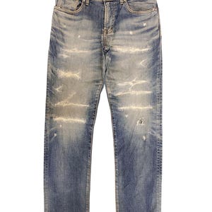 May include: Faded blue denim jeans with distressed detailing. The jeans feature a classic five-pocket design, a button and zipper closure, and visible wear and tear throughout the fabric. The jeans have a straight leg cut.