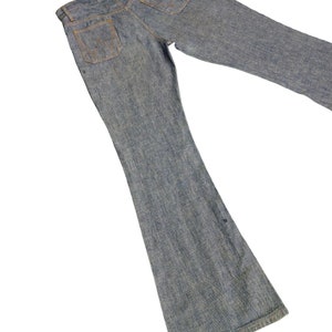 May include: A pair of blue denim bell bottom jeans. The jeans have a light wash and are made of a soft, comfortable fabric.