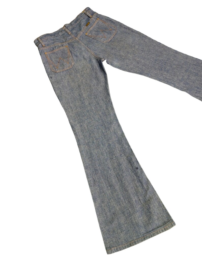May include: A pair of blue denim bell bottom jeans. The jeans have a light wash and are made of a soft, comfortable fabric.