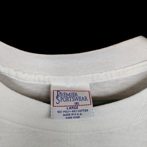 May include: White tag with black text that reads "Premier Sportswear Inc." and "Large 50% Poly-50% Cotton Made in U.S.A. Care Over"