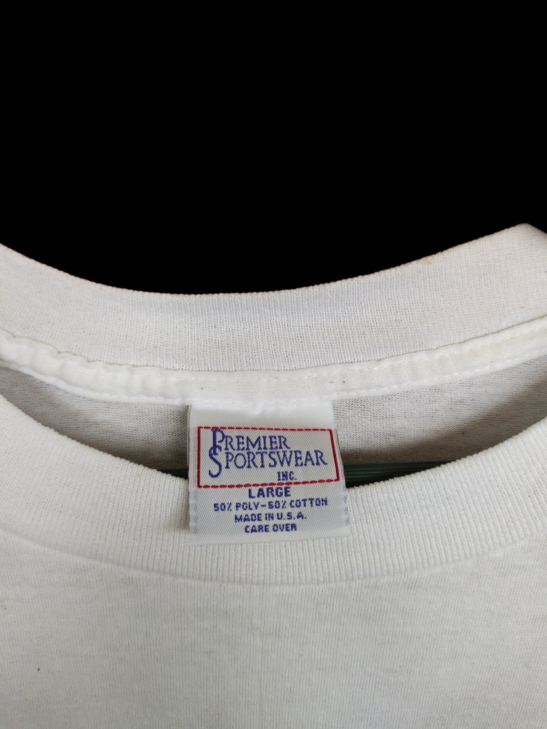May include: White tag with black text that reads "Premier Sportswear Inc." and "Large 50% Poly-50% Cotton Made in U.S.A. Care Over"