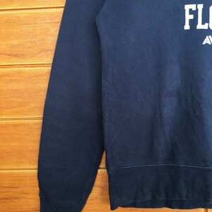 May include: A dark blue sweatshirt with white text that reads "University of Florida Gators" on the front.