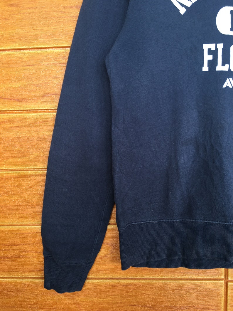 May include: A dark blue sweatshirt with white text that reads "University of Florida Gators" on the front.