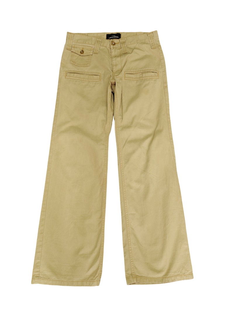 Puede incluir: Un pantal&oacute;n cargo beige de pierna recta con m&uacute;ltiples bolsillos.