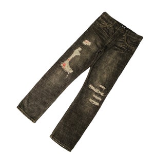 Könnte beinhalten: Verwaschene dunkelgraue Jeans mit mehreren Rissen und Löchern im gesamten Stoff. Die Jeans haben einen ausgewaschenen Look und eine lockere Passform.