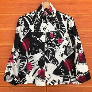 May include: A black and white button-up shirt with a pink and white geometric pattern. The shirt has a collar and long sleeves. The text "BRIGHT" and "BRIOHT" is visible on the shirt.