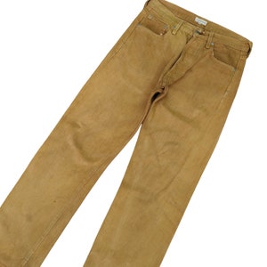 May include: A pair of brown denim jeans with a straight leg fit. The jeans are made from a thick, durable fabric and have a faded look.