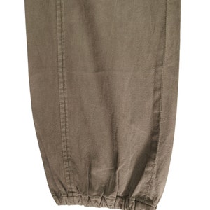 May include: Close-up of the bottom of a pair of brown pants with a drawstring.