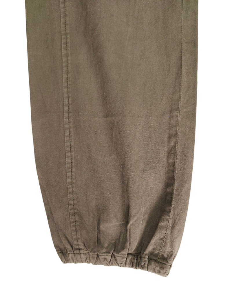 May include: Close-up of the bottom of a pair of brown pants with a drawstring.