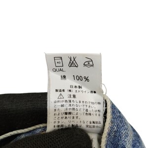 Puede incluir: Una etiqueta blanca con texto y s&iacute;mbolos japoneses, adherida a una tela vaquera. La etiqueta incluye instrucciones de lavado y el texto "綿 100%" que indica 100% algod&oacute;n. La etiqueta tambi&eacute;n tiene el texto "日本製" que significa "Hecho en Jap&oacute;n".