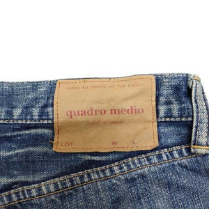 Puede incluir: Una taza de cer&aacute;mica blanca con un asa negra y el texto "But First, Coffee" en negrita negra. La taza est&aacute; llena de un l&iacute;quido oscuro, probablemente caf&eacute;, y se encuentra sobre una superficie clara.