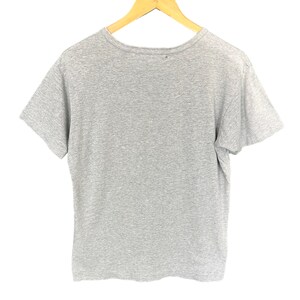 Może przedstawiać: Szara koszulka z kr&oacute;tkim rękawem i okrągłym dekoltem.