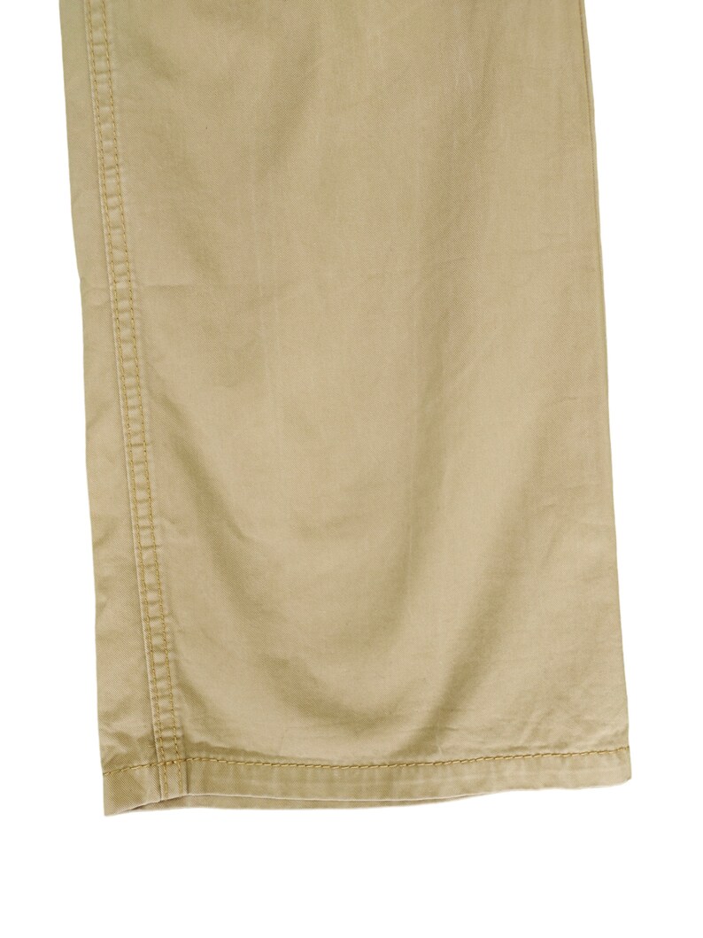 Puede incluir: Un pantal&oacute;n cargo beige con una costura en el lateral de la pierna.