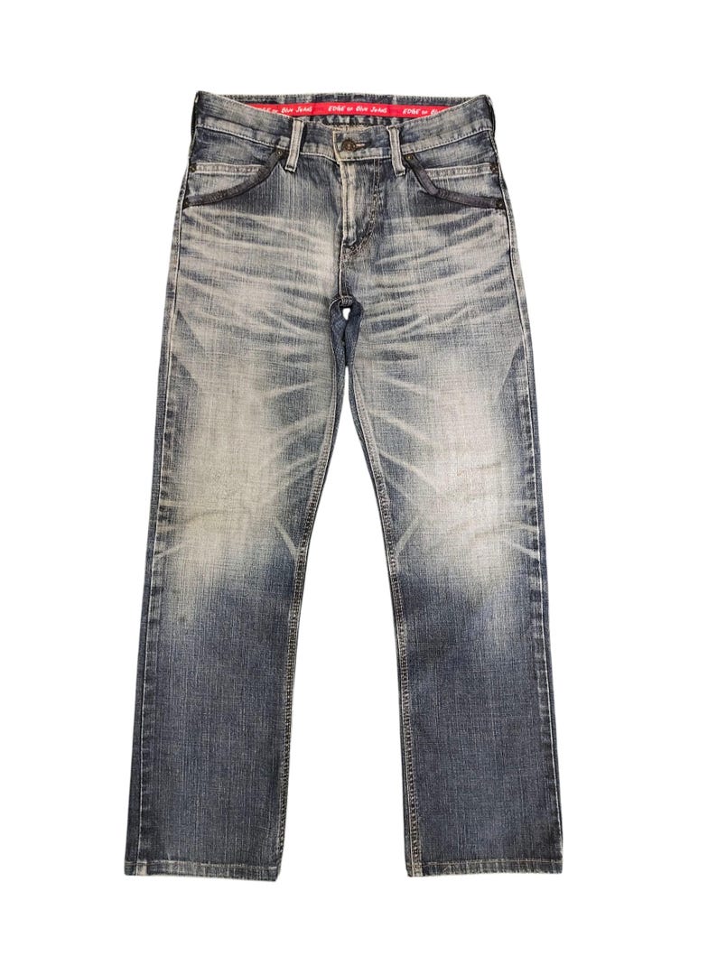 May include: Faded blue denim jeans with a straight leg cut. The jeans have a worn appearance with lighter areas on the thighs and knees. A red tag is visible on the inside waistband. The jeans have classic five-pocket styling.