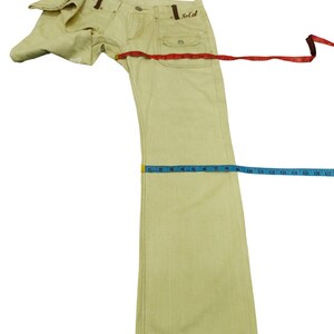 Puede incluir: Pantalones vaqueros de color amarillo claro con un dise&ntilde;o de pernera recta. Los pantalones tienen cierre de bot&oacute;n y cremallera, trabillas para el cintur&oacute;n y dos bolsillos delanteros. La palabra "So Cal" est&aacute; bordada en el bolsillo trasero. Los pantalones se miden con una cinta m&eacute;trica.