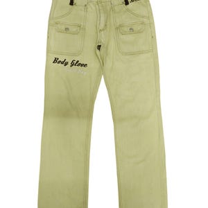 Puede incluir: Pantalones vaqueros de color amarillo claro con corte recto. Los pantalones tienen dos bolsillos delanteros, dos bolsillos traseros y cierre de bot&oacute;n y cremallera. Las palabras "Body Glove South Bay" est&aacute;n impresas en la pierna izquierda y "SoCal" en el bolsillo derecho.