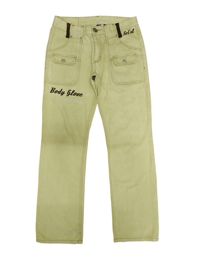 Puede incluir: Pantalones vaqueros de color amarillo claro con corte recto. Los pantalones tienen dos bolsillos delanteros, dos bolsillos traseros y cierre de bot&oacute;n y cremallera. Las palabras "Body Glove South Bay" est&aacute;n impresas en la pierna izquierda y "SoCal" en el bolsillo derecho.